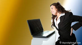 a person New Roads bending over a computer holding her back due to pain